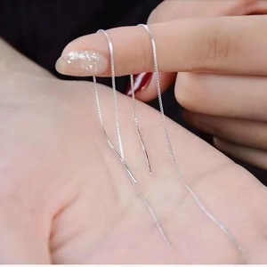 Detailed view of silver s925 long tassel earrings displayed on a hand model