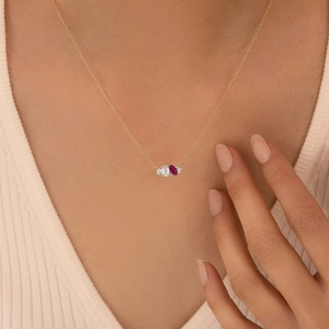 Luxe gold necklace featuring emerald cut clear stone and marquise red zircon pendant