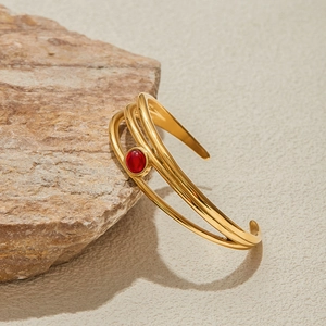 Dettaglio del bracciale aperto in acciaio inossidabile dorato 18K con pietra rossa