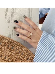 Detail of model wearing a gold twisted band ring set with a clear center stone and plain band