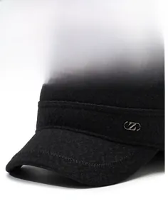 Detail of a black wool flat cap showing the firm brim and stylish metal logo accent