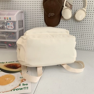 Minimalist cream college backpack for travel and laptop use on a cozy desk background
