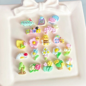 Mini resin nail art accessories in candy colors featuring flowers and bees on a pink tray