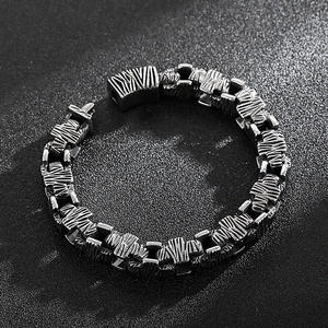 Detail of vintage stainless steel cross chain bracelet with distressed silver-black finish