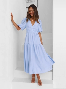 Detail view of light blue V-neck dress with puff sleeves and textured fabric on stairs