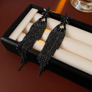 Vue macro de boucles d'oreilles noires à pampilles en strass dans un coffret cadeau
