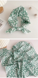 Detail of green floral silk scarf with elegant pattern and soft fabric texture