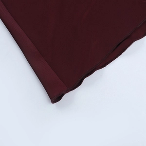 Close-up of the wine red satin dress hemline showing precision stitching detail