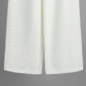 Detail view of white plush knit trousers showing soft texture and premium fuzzy fabric