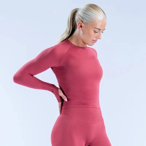 Detail van ergonomische lange mouwen met duimgaten op een roze yogaset