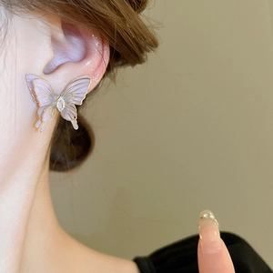 Close-up detail of a lavender butterfly stud earring with gold edges and a zircon center