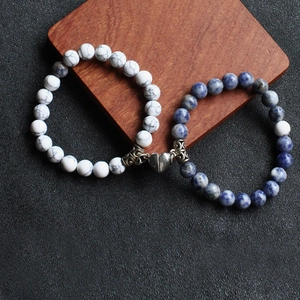 Detail of couple bracelets with magnetic heart clasp and colorful natural stone beads