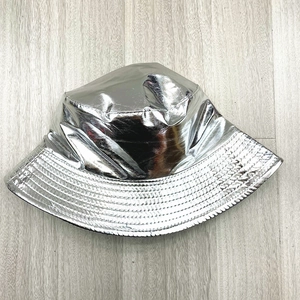 Detailed view of silver metallic bucket hat with reflective texture on wooden floor