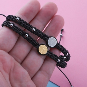 Adjustable black cord bracelet with Saint Benedict medal showing etched geometric patterns