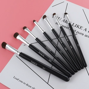 Close-up of 7 professional makeup brushes with matte black handles and silver ferrules