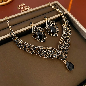 Detailed view of vintage gold V-shape jewelry set with black teardrop rhinestones