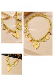 Detail of bohemian gold chain necklace with green cord, heart pendant and colorful beads
