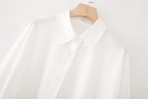 Close-up of white cotton poplin shirt collar and buttons on a wooden hanger