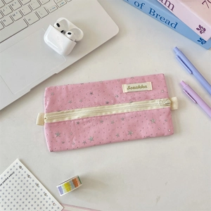 Detail of pink star pattern canvas pencil case with brand label on a tidy study desk