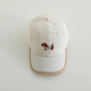 Close-up of cute puppy embroidery on cream cotton baseball cap for kids and toddlers