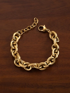 Detail of 18k gold plated chunky chain bracelet with lobster clasp on wooden background
