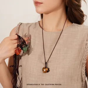 Vintage heart gemstone necklace with woven rope, featuring tiger eye and rose quartz stones