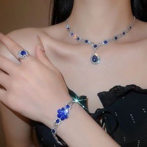 Detail of luxury teardrop flower jewelry set with sparkling blue stones on model