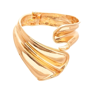Modern wavy gold metal cuff bracelet with irregular geometric design on white background