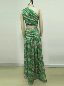 Detail of green palm print two-piece set featuring one-shoulder top and gold chain belt