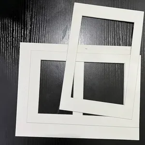 Stack of professional white rectangle picture frame mat boards on wood background