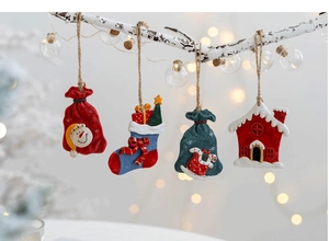 Four festive resin Christmas ornaments including snowman bag and stocking on white branch