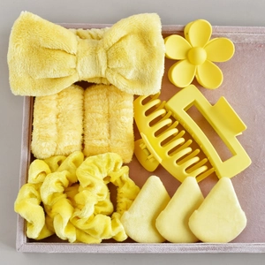 Macro shot of 8-piece yellow personal care set with bow headband and hair clips