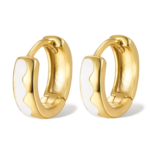 Macro detail of gold 925 sterling silver hoop earrings with white enamel and wavy edges