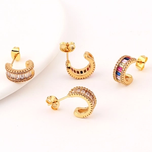 Detailed view of gold C-shaped earrings with clear and multicolor zircon micro-paving