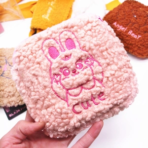 Close-up of pink sherpa fleece sanitary pad bag with cute rabbit embroidery detail