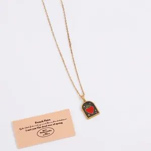 Vintage gold necklace featuring a rectangular tarot pendant with red heart and star details