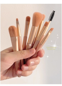 Macro shot of a portable 8-piece pink makeup brush set held in hand for precision detail