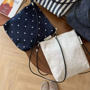 Flat lay of vintage striped and denim cotton linen mini crossbody bags on a wooden table