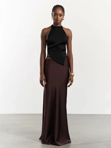 Détail du haut dos nu noir à ourlet asymétrique associé à une jupe en satin