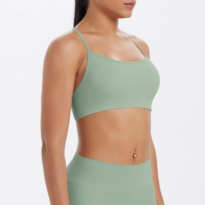 Détail de la brassière de sport vert sauge croisée et du legging taille haute mat