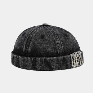 Detail of washed denim miki hat featuring frayed fringe embroidery and vintage texture