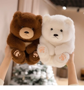 Close-up of soft plush teddy bear paws featuring detailed embroidered pads in warm lighting