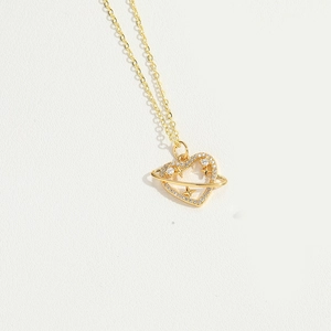 Detailed view of a gold heart pendant necklace with white zircon on a white background