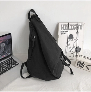Detailed close-up of a black canvas crossbody bag with buckle and zipper hardware