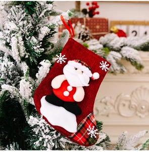 Detailed view of burlap Christmas stocking with Santa Claus and snowflake hanging on a tree