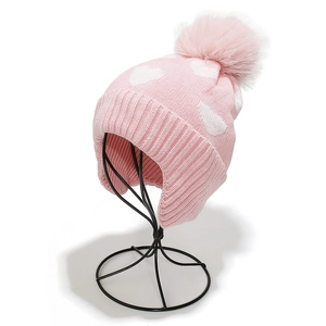 Rosafarbene Strickmütze mit weißen Herzmustern, Ohrenklappen und flauschigem Bommel