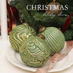 Close-up of 8cm vintage green and gold Christmas balls with embossed relief textures