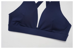 Detail of dark blue racerback yoga bra featuring V-neckline and reinforced wide hem