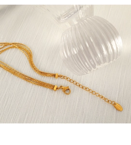 Detail view of gold multi-layer snake chains with S.Steel hallmark tag and lobster clasp