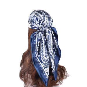Detailed back view of a blue and white paisley satin square scarf tied as a headscarf